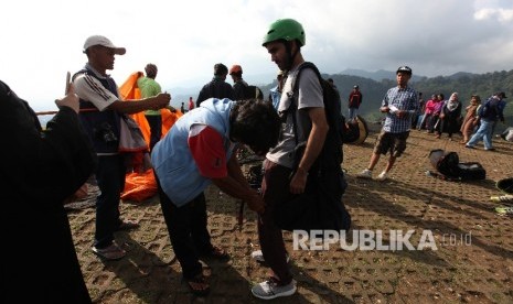 Sejumlah pengujung mencoba wisata paralayang di kawasan puncak, Bogor, Jawa Barat, Jumat (6/5).   (Republika/Rakhmawaty La'lang)