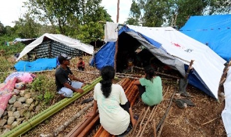 Sejumlah pengungsi korban gempa bumi memperbaiki tenda yang ditempatinya di lokasi pengungsian Desa Waai, Pulau Ambon, Kecamatan Salahutu, Kabupaten Maluku Tengah, Sabtu (5/10). Para pengungsi tersebut mengungsi ke hutan dan menempati tenda-tenda yang dibangun sendiri pascagempa yang mengguncang Pulau Ambon dan sekitarnya, Kamis (26/9). 