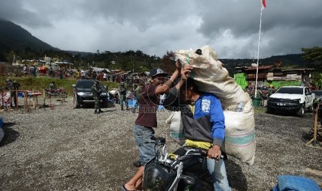 Sejumlah pengungsi korban kebakaran kios menyiapkan barangnya untuk kemudian dipindahkan ke Kantor Bupati Tolikara, Papua, Jumat (24/7).   (Republika/Raisan Al Farisi)