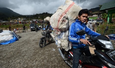 Sejumlah pengungsi korban kebakaran kios menyiapkan barangnya untuk kemudian dipindahkan ke Kantor Bupati Tolikara, Papua, Jumat (24/7).  (Republika/Raisan Al Farisi)