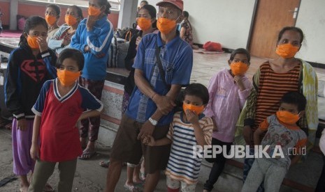 Sejumlah pengungsi mengenakan masker setelah terjadi hujan abu letusan Gunung Agung, di lokasi penampungan Desa Bebandem, Karangasem, Bali, Ahad (26/11). 