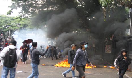 Sejumlah pengunjuk rasa melempari gedung DPRD dengan berbagai benda saat aksi menolak pengesahan Undang-Undang Cipta Kerja atau Omnibus Law di Malang, Jawa Timur, Kamis (8/10/2020). Unjuk rasa tersebut mengakibatkan sejumlah polisi luka-luka dan satu unit mobil polisi rusak.