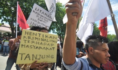 Sejumlah pengunjuk rasa yang tergabung dalam Front Solidaritas Untuk Masyarakat Tanjung membawa poster saat berunjuk rasa di Depan Mapolda Sulawesi Tengah di Palu, Selasa (20/3). Aksi ratusan pengunjuk rasa itu memprotes eksekusi lahan di Tanjung Sari, Kelurahan Karaton, Kecamatan Luwuk, Kabupaten Banggai, Sulawesi Tengah. 