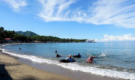 Rapat Pemda Gorontalo Utara Mulai Digelar di Tempat Wisata. Sejumlah pengunjung berenang dan bermain di objek wisata Pantai Botutonuo, Kabupaten Bone Bolango, Gorontalo, Ahad (23/5/2021). Objek wisata di Bone Bolango kembali dibuka setelah sempat ditutup mulai tanggal 12-20 Mei 2021, baik yang dikelola oleh pemda maupun masyarakat dalam upaya pencegahan COVID-19.