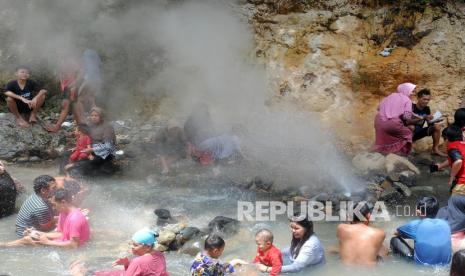 Sejumlah pengunjung berendam di sumber air panas.