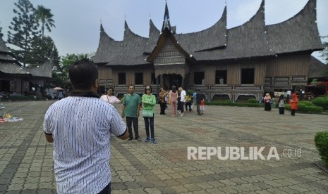  Sejumlah pengunjung berfoto Anjungan Sumatra Barat di Taman Mini Indonesia Indah, Jakarta Timur, Rabu (5/7).