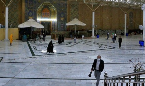 Sejumlah pengunjung berjalan di Masjid Ali di Najaf, Iran, Selasa (25/2). Iran berlakukan pembatasan kunjungan parsial pada situs suci Syiah dan khotbah Jumat di beberapa kota tidak akan diadakan minggu ini.