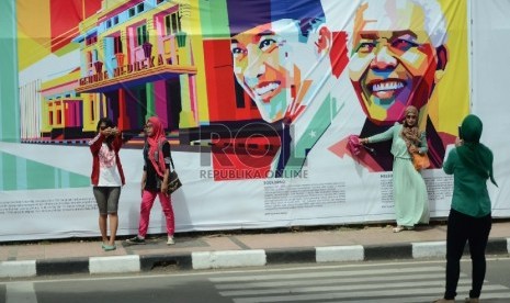 Sejumlah pengunjung berselfie ria di gambar Soekarno dan Nelson Mandela. Meski puncak perayaan Konferensi Asia Afrika (KAA) ke-60 telah usai namun kepadatan pengunjung masih terjadi di kawasan Gedung Merdeka, Jl Asia Afrika, Kota Bandung, Ahad (26/4). 