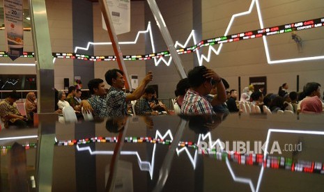 Sejumlah pengunjung duduk berlatar belakang pergerakan Indeks Harga Saham Gabungan (IHSG) di Bursa Efek Indonesia, Jakarta, Jumat (22/6).