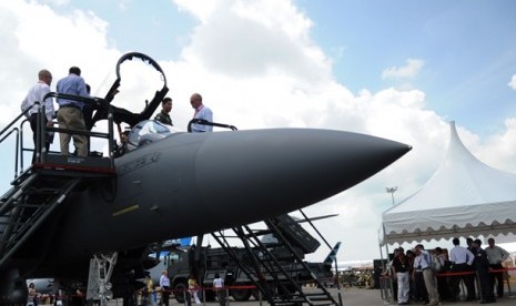 Sejumlah pengunjung melihat dari dekat pesawat tempur F-15 SG, sementara belasan pengunjung lainnya (sebelah kanan) antre menunggu giliran merasakan duduk di kursi pilot pesawat tempur Singapura tersebut pada Singapore Airshow 2012, Rabu (15/2). Singapore 