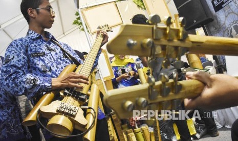 Sejumlah pengunjung mencoba alat musik gitar berbahan bambu di Virageawie Indonesia pada Pameran UMKM di area Komplek Perkantoran Pemda Kabupaten Bandung Barat, Rabu (19/6). 