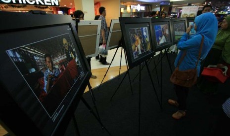   Sejumlah pengunjung mengamati karya foto saat pameran foto Bank BJB di Bandung Indah Plaza, Bandung, Sabtu (21/12).  (Antara/Dedhez Anggara)