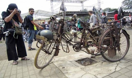  Sejumlah pengunjung mengamati sepeda pengangkut amunisi dalam kondisi masih asli pada acara 'Bandung Lautan Onthel' di kawasan Lapangan Gasibu,Bandung, Ahad (24/3).  (Republika/Edi Yusuf)