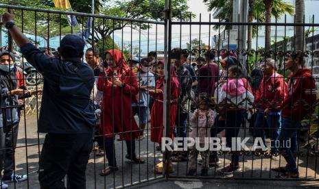 Sejumlah pengunjung mengantre untuk membeli tiket masuk ke wahana permainan air di Ampera Water Park, Ciawi, Kabupaten Tasikmalaya, Jawa Barat, Ahad (16/5/2021). Pada H+3 libur Lebaran kunjungan wisata yang menyediakan air panas alami itu masih ramai, pengelola membatasi jumlah kapasitas pengunjung agar tidak terjadi kerumunan.