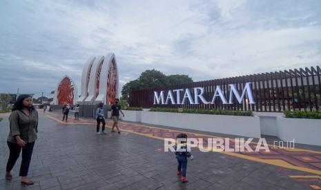 Sejumlah pengunjung menikmati suasana di gerbang selatan Taman Sangkareang di Mataram, NTB, Jumat (11/2/2022). Pemerintah Kota Mataram Provinsi Nusa Tenggara Barat akan melakukan pengawasan terhadap sejumlah objek wisata serta ruang publik selama libur dan cuti Idul Fitri 1443 Hijriah.