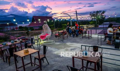 Sejumlah pengunjung menikmati suasana di salah satu kafe yang baru dibuka di Palu, Sulawesi Tengah, Sabtu (7/11/2020). Meskipun bisnis sempat lesu karena pembatasan sosial akibat pandemi Covid-19, pemerintah setempat memberi izin kembali usaha kafe baik yang lama maupun yang baru untuk beroperasi dengan tetap menerapkan protokol kesehatan. 