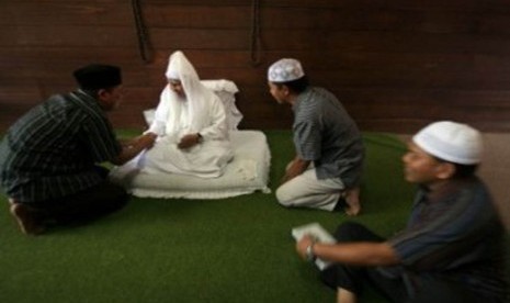 Sejumlah pengunjung menyalami Tuan Guru Syekh H Hasyim Al-Syarwani (tengah) keturunan ke-11 dari Tuan Guru Syekh Abdul Wahab Rokan saat berwisata religi di Pesantren Babussalam, Kabupaten Langkat, Sumut, Sabtu (7/1). 