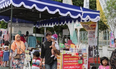 Sejumlah pengunjung terlihat berjalan di depan stan bazar Tabligh Akbar Republika 2016 di depan Masjid Syuhada Yogyakarta, Jumat (30/12). Bazar akan berlangsung selama dua hari pada 30-31 Desember 2016.