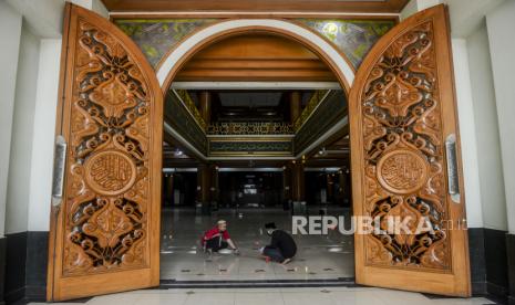 Sejumlah pengurus masjid memasangkan tanda silang untuk membatasi shaf jamaah di Masjid Agung Al-Barkah, Kota Bekasi, Jawa Barat.