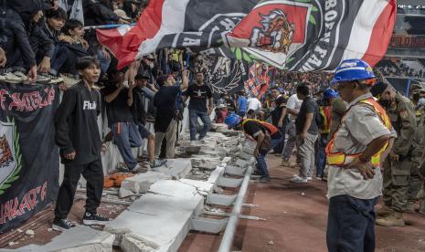 Sejumlah penonton berdiri di atas puing pagar pembatas yang roboh saat peresmian Stadion Jakarta International Stadium (JIS) di Jakarta, Ahad ( 24/7/2022). Pagar pembatas penonton zona utara JIS roboh karena tidak dapat menahan beban orang yang duduk dan bersandar di pagar tersebut. 