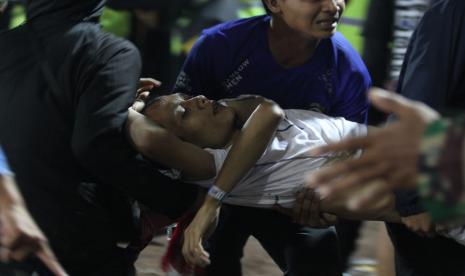  Sambil Menangis Ketakutan, Anak TK Selamat dari Tragedi Kanjuruhan: Mama yang Suka Bola. Foto: Sejumlah penonton membawa rekannya yang pingsan akibat sesak nafas terkena gas air mata yang ditembakkan aparat keamanan dalam kericuhan usai pertandingan BRI Liga 1 antara Arema melawan Persebaya di Stadion Kanjuruhan, Malang, Jawa Timur, Sabtu (1/10/2022) malam. Polda Jatim mencatat jumlah korban jiwa dalam kerusuhan tersebut sementara sebanyak 127 orang. 