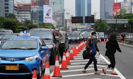  Sejumlah penumpang angkutan umum terpaksa berjalan kaki keluar pintu tol depan Polda Metro Jaya, Jakarta, Rabu (29/1).   (Republika/Adhi Wicaksono)  