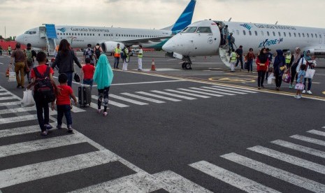 Sejumlah penumpang berjalan di area parkir pesawat saat tiba di Bandara Ahmad Yani, Semarang, Jawa Tengah, Ahad (18/6). PT Angkasa Pura I Bandar Udara Ahmad Yani memprediksi puncak arus mudik Lebaran 2017 akan terjadi pada H-2 Lebaran.