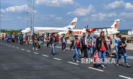 Sejumlah penumpang berjalan di area parkir pesawat saat tiba di Bandara Internasional Ahmad Yani, Semarang, Jawa Tengah, Senin (11/6). 