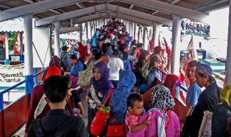 Sejumlah penumpang berjalan menuju kapal roro untuk menyebrang ke pulau sumatra melalaui Pelabuhan Merak ,Banten, Senin (28/7).