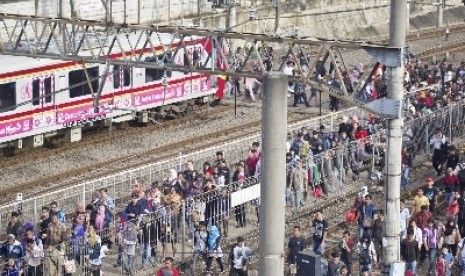   Sejumlah penumpang kereta api berdesakan ketika antre untuk keluar di Stasiun Tanah Abang, Jakarta, Kamis (12/3).