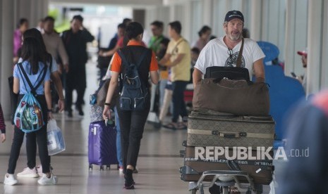 Sejumlah penumpang membawa barang bawaan di Terminal Domestik Bandara Ngurah Rai. 