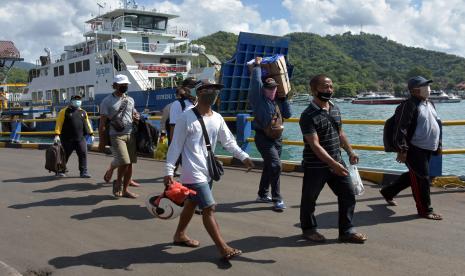 Sejumlah penumpang membawa barang menuju kapal saat akan menyeberang ke Pulau Nusa Penida di Pelabuhan Padangbai, Karangasem, Bali, Selasa (28/4/2020). Pelabuhan Padangbai masih beroperasi namun terbatas hanya untuk kendaraan pengangkut barang atau Logistik, penumpang menuju Pulau Nusa Penida, dan penumpang dengan Kartu Tanda Penduduk (KTP) Provinsi NTB menyusul kebijakan pemerintah setempat yang mengizinkan warganya pulang kampung di tengah pandemi COVID-19. 