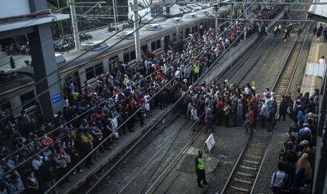 Sejumlah penumpang mengantre saat berpindah kereta rel listrik (KRL) di peron Stasiun Duri, Jakarta, Senin (16/4). 