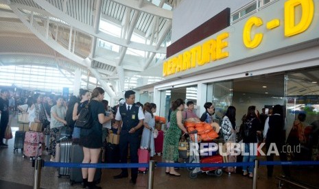 Sejumlah penumpang menunggu jadwal penerbangan di Bandara Ngurah Rai, Bali, Jumat (29/6). 