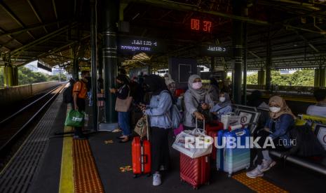 Sejumlah penumpang menunggu kedatangan kereta di Stasiun Gambir, Jakarta, Sabtu (4/9). 