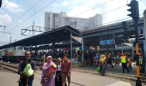 Sejumlah penumpang sedang melintasi rel kereta di Stasiun Bekasi, Kota Bekasi, pada Ahad (14/4). Tampak Stasiun Bekasi sudah tidak mengalami penumpukan lagi meski uji coba jalur dwi ganda masih berlangsung.