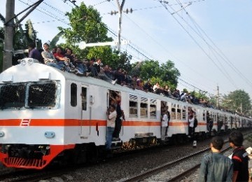 Sejumlah penumpang yang berada diatas kereta berusaha menghindar dari penghalang penumpang 'pintu koboi' saat melintas di kawasan Kalibata, Jakarta Selatan, Senin (27/6).