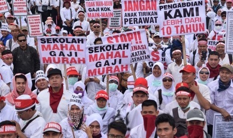 Sejumlah perawat yang tergabung dalam Persatuan Perawat Nasional Indonesia (PPNI) membawa poster saat menggelar unjuk rasa di depan Gedung DPR/MPR, Jakarta, Kamis (16/3). 