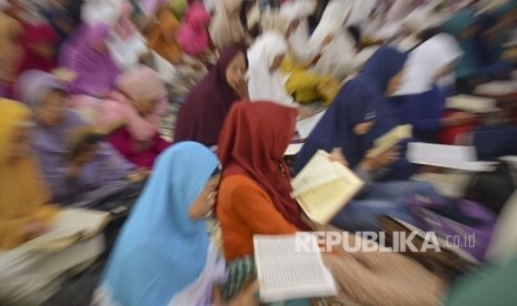 Sejumlah perempuan membaca kitab suci Al Quran saat mengikuti tadarus Al Quran Ramadhan 1438 H bersama ratusan umat muslim dari organisasi perempuan NTB di Pendopo Gubernur NTB di Mataram, Selasa (30/5).  