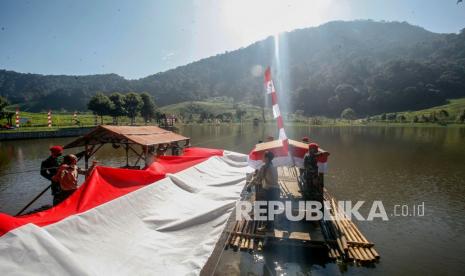 Sejumlah personel Komando Pasukan Khusus (Kopassus) Batalyon 14/Bhadrika Sena Baladika membentangkan kain merah putih di titik nol Ciliwung, Telaga Saat, Cisarua, Puncak, Kabupaten Bogor, Jawa Barat, Ahad (16/8/2020). Kain merah putih sepanjang 100 meter dengan lebar 4 meter dibentangkan di Telaga itu dalam rangka peringatan HUT ke-75 RI. 