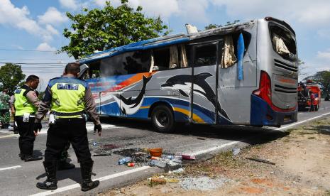 Sejumlah personel polisi melakukan identifikasi di lokasi kecelakaan tunggal Bus Sugeng Rahayu di Balerejo, Kabupaten Madiun, Jawa Timur, Selasa (31/5/2022). Penyebab kecelakaan yang mengakibatkan 20 penumpang mengalami luka itu masih dalam penyelidikan pihak kepolisian. 