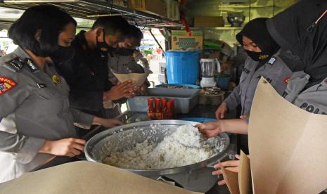 Sejumlah personel Polri menyiapkan nasi bungkus di dapur umum untuk pengungsi korban banjir di Serang, Banten, Sabtu (5/3/2022). Banjir yang melanda Serang dan sekitarnya tanggal 1-3 Maret lalu mengakibatkan delapan orang meninggal dunia, 2.413 rumah terendam dan 3.500 warga mengungsi. 