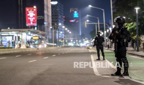 Sejumlah personel Satbrimob Polda Metro Jaya berjaga saat pemberlakuan Crowd Free Night di Bundaran Hotel Indonesia, Jakarta.