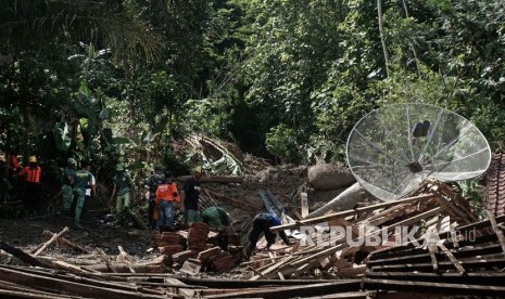 Sejumlah personel Tagana bersama relawan dan warga membersihkan puing rumah, yang roboh terkena longsor di Desa Cihonje, Gumelar, Banyumas, Jawa Tengah, Senin (18/12). 