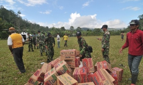 Sejumlah personel TNI AD dari Yonif 711 Raksatama bersama warga menurunkan logistik bantuan dari helikopter di Desa Langko, Kecamatan Lindu, Kabupaten Sigi, Sulawesi Tengah, Rabu (22/8).