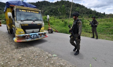 Sejumlah personil Brimob yang tergabung dalam Satuan Tugas (Satgas) Operasi Tinombala 2017 memeriksa kendaraan yang melintas di Pos Pengamanan di Desa Sedoa, Kecamatan Lore Utara, Kabupaten Poso, Sulawesi Tengah, Minggu (2/4). 