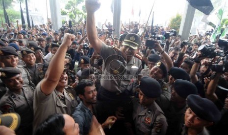 Sejumlah personil kepolisian dan massa pendukung Budi Gunawan menggendong personel kepolisian sebagai ungkapan syukur usai sidang praperadilan pemohon Komjen Budi Gunawan di Pengadilan Negeri Jakarta Selatan, Senin, (16/2).