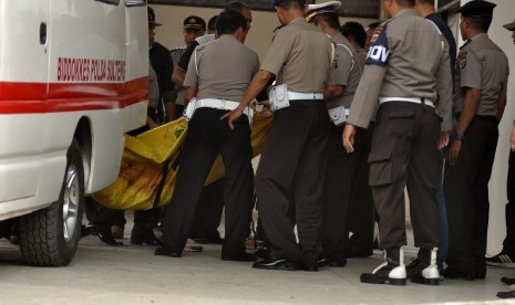 Sejumlah personil membawa kantong jenazah ke ruang jenazah di RS Bhayangkara Palu, di Palu, Sulawesi Tengah, Selasa (19/7).