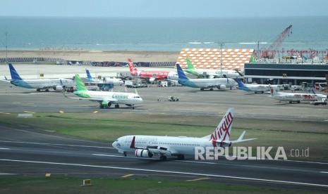 Sejumlah pesawat udara berada di apron dan landasan Bandara Internasional I Gusti Ngurah Rai, Bali, Selasa (17/12/2019). 