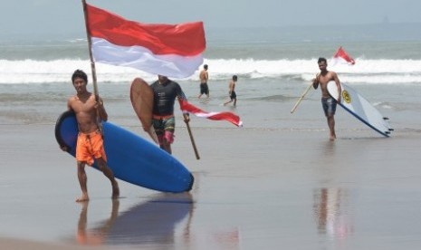 (Foto terkait) Sejumlah peselancar yang terabung dalam komunitas anak pantai mengibarkan bendera Merah Putih, di Pantai Berawa, Badung, Bali, Selasa (15/8). Kegiatan tersebut untuk menghormati para pahlawan bangsa sekaligus memperingati HUT ke-72 Kemerdekaan Republik Indonesia. 